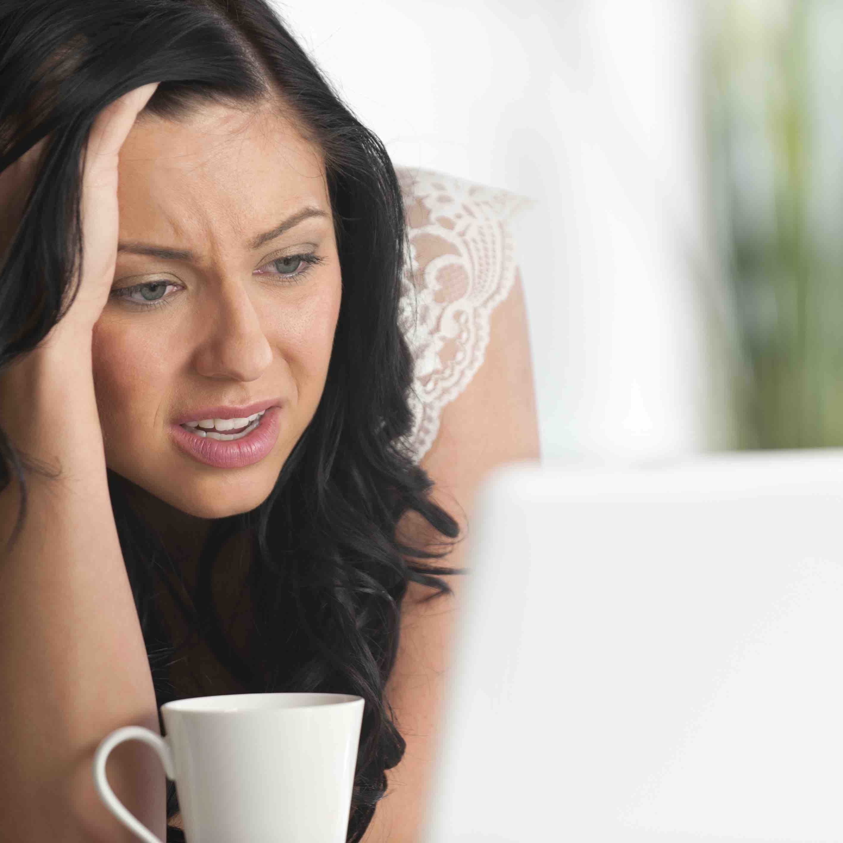 Frustrated woman looking at a laptop computer with her hand in her hair